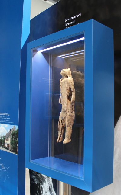 In einer Vitrine ist eine Replik des Löwenmenschen ausgestellt, eine aus Mammutelfenbein geschnitzte Figur – halb Mensch, halb Löwe.