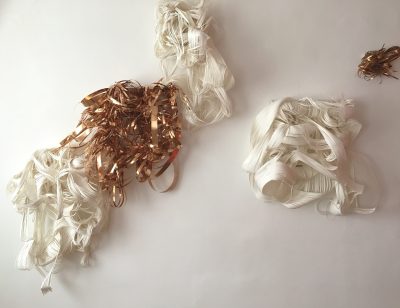 Verschiedene Haufen aus ineinander verschlungenen Fäden und Streifen.