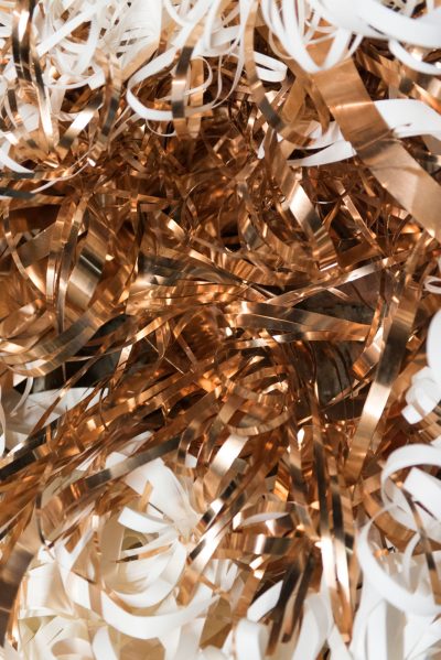 Ein Geflecht aus gekringelten und in sich verwobenen Streifen aus verschiedenen Materialien.