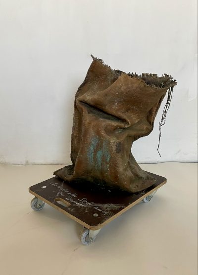 Reiner Schlecker, Soll der alte Sack auch ins Depot, 2021, Bronze patiniert, Transportwagen