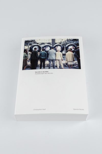 Farbfoto: Ein weißes Buch liegt auf einem hellgrauen Untergrund