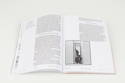 Farbfoto: Ein aufgschlagenes Buch liegt auf einem weißen Hintergrund. Zu sehen ist eine weiße aufgeschlagene Doppelseite.