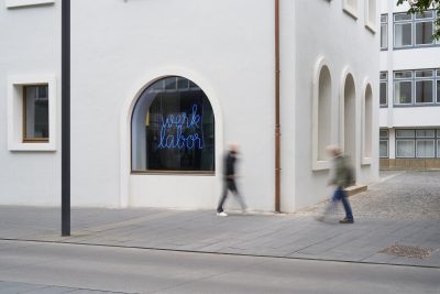 farbfoto: Blick auf ein weißes Gebäude mit großen Rundbogenfenstern